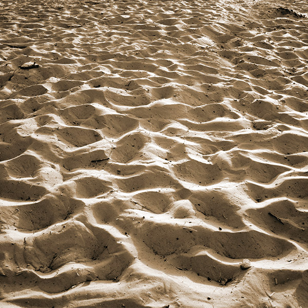 The sand of a beach along a river